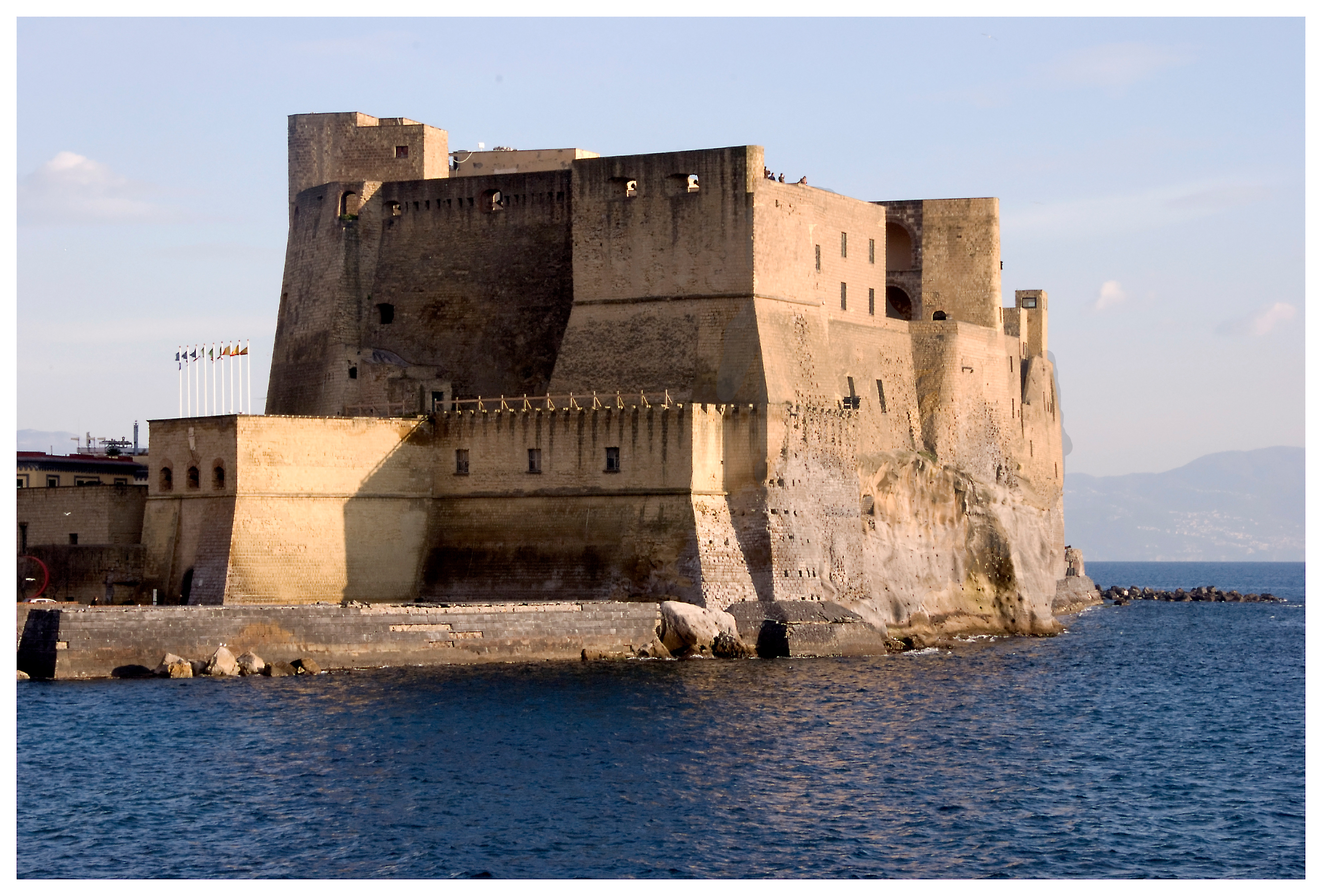 Castel dell'Ovo in controluce dorato sul mare di Napoli