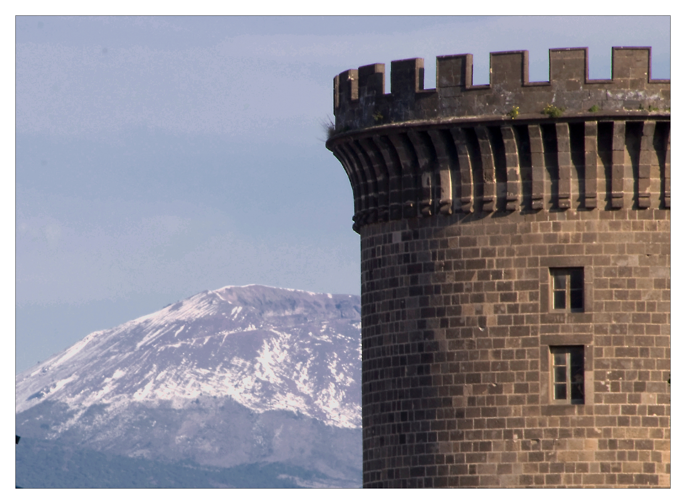 La torre del Maschio Angioino con il Vesuvio innevato sullo sfondo